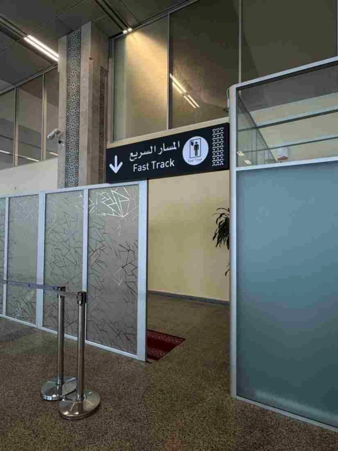 Fast Track sign above a partitioned airport passenger passage.